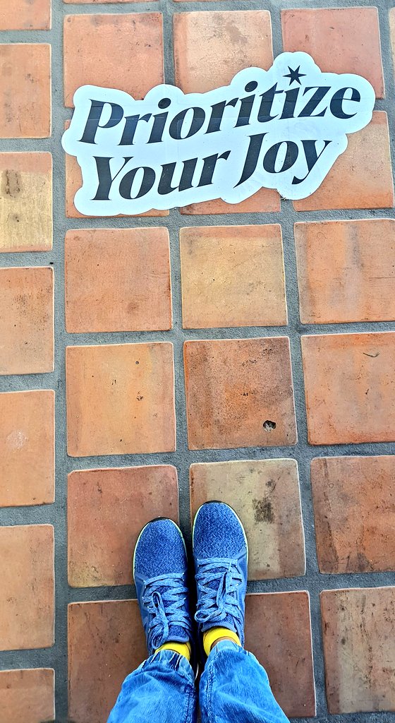 A cobblestone path with a sticker that says ‘Prioritize your joy’