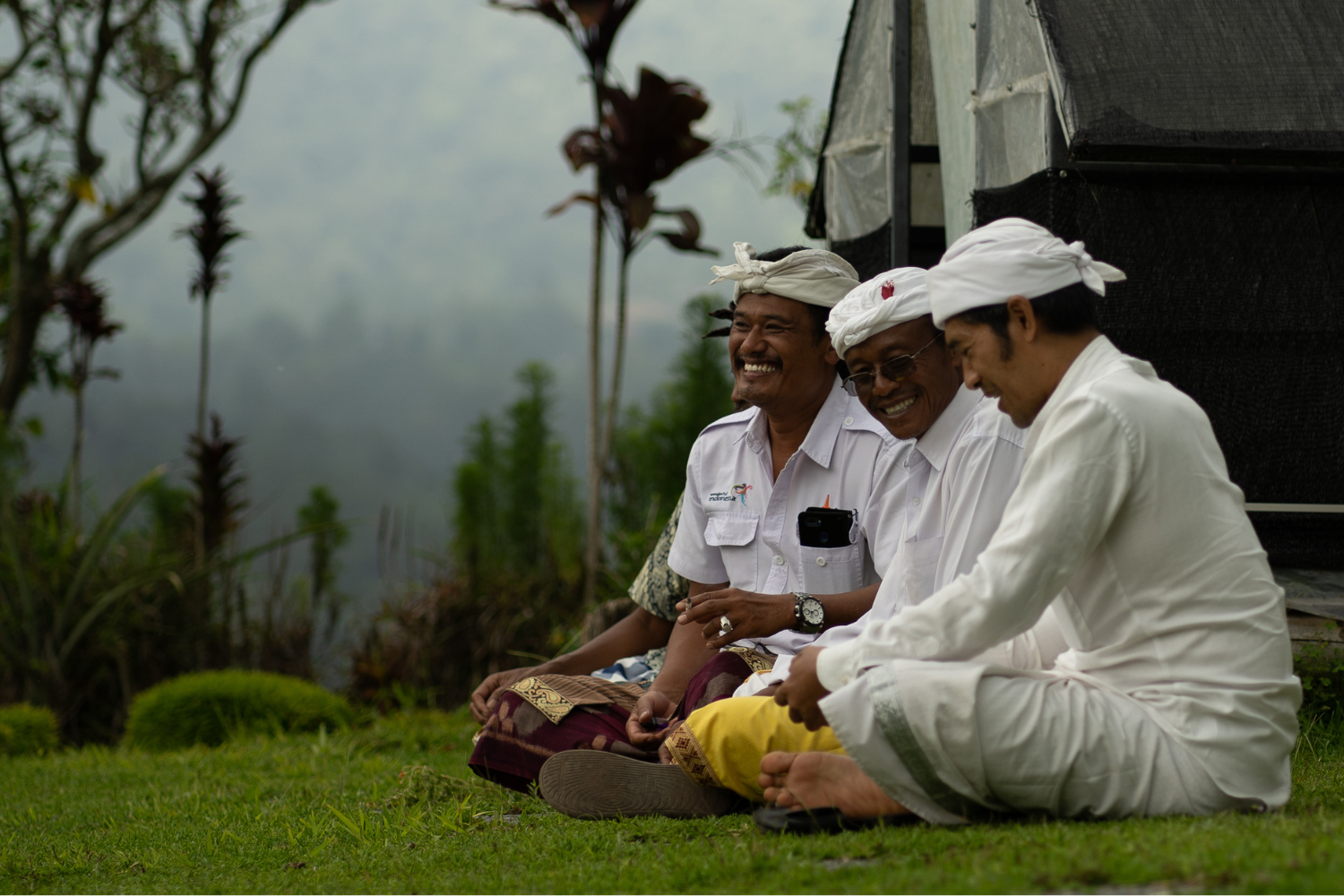 Three Kintamani coffee farmers sitting on a field.